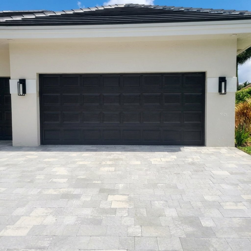 Dark charcoal raised-panel two-car garage door on a white stucco home